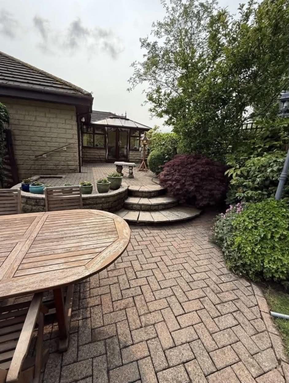 Freshly cleaned block-paved patio and curved garden steps after jet washing